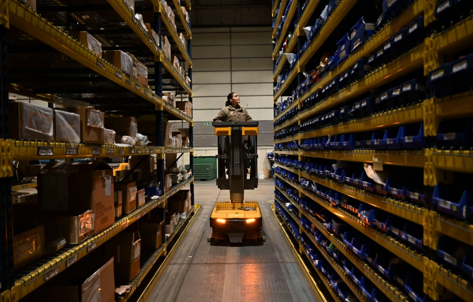 A professional on a lift manages inventory in a warehouse.