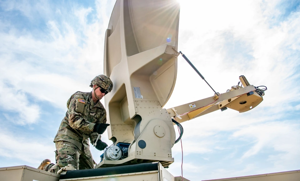 A soldier performs maintenance on a tactical satellite terminal. A soldier performs maintenance on a tactical satellite terminal.
